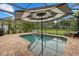 Inviting screened-in pool area with brick pavers, shaded seating, and lush landscaping for outdoor enjoyment at 12224 Longview Lake Cir, Bradenton, FL 34211