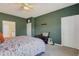 Green-walled bedroom with king bed, guitar, and ceiling fan at 13707 Woodbridge Ter, Bradenton, FL 34211