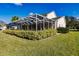 Home with large backyard, screened patio, and lush hedges at 14106 18Th E Pl, Bradenton, FL 34212