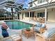 Inviting pool area with lanai, wicker furniture, and lush landscaping at 14106 18Th E Pl, Bradenton, FL 34212