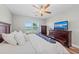 Large main bedroom with wooden furniture, ceiling fan, and lake view at 15218 Agave Grove Pl, Bradenton, FL 34212