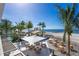Casual beachfront dining with tables and umbrellas on the sand at 1561 Gulf Of Mexico Dr # 403, Longboat Key, FL 34228