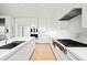 Modern kitchen with white cabinetry, marble countertops, and high-end appliances at 1561 Gulf Of Mexico Dr # 403, Longboat Key, FL 34228