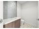 Stylish powder room with wood vanity and pebble floor at 1591 Gulf Of Mexico Dr # 413, Longboat Key, FL 34228
