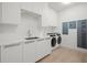 Modern laundry room with washer, dryer, and utility sink at 1591 Gulf Of Mexico Dr # 413, Longboat Key, FL 34228