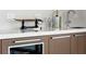 Modern wet bar with wine cooler, sleek cabinetry, and quartz countertops at 1591 Gulf Of Mexico Dr # 413, Longboat Key, FL 34228