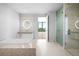 Bright bathroom featuring double vanity, marble flooring, modern soaking tub, and glass shower at 1591 Gulf Of Mexico Drive # 311, Longboat Key, FL 34228