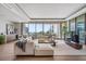 Open-concept living room features a sectional sofa, a bar, and expansive windows with beautiful ocean views at 1591 Gulf Of Mexico Drive # 311, Longboat Key, FL 34228