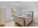 Bright bedroom with light hardwood floors and a neutral-toned bed at 16247 Hidden Oak Loop, Bradenton, FL 34211