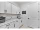 Bright laundry room with white cabinets and quartz countertops at 16247 Hidden Oak Loop, Bradenton, FL 34211