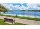 Tranquil lakeside scene with a bench and walking path, offering serene waterfront living at 16247 Hidden Oak Loop, Bradenton, FL 34211