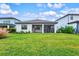 Home with covered patio, grassy yard, and mature plantings at 16247 Hidden Oak Loop, Bradenton, FL 34211