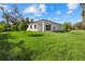 New home with a spacious backyard, bright green grass and trees at 1800 S San Mateo Dr, North Port, FL 34288