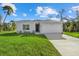 Beautiful single-story home with a manicured lawn, a well-lit front door, and an attached garage at 1800 S San Mateo Dr, North Port, FL 34288