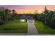 Stunning single-story home with a well-manicured lawn and a long driveway, at sunset at 1800 S San Mateo Dr, North Port, FL 34288