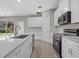 Modern kitchen featuring quartz countertops, stainless appliances and light wood flooring at 1800 S San Mateo Dr, North Port, FL 34288