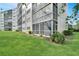 Exterior view of building with screened in lanai and green lawn at 3660 Ironwood Cir # 101M, Bradenton, FL 34209