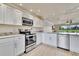 Modern kitchen with white cabinetry, stainless appliances, granite counters, and open to living area at 3660 Ironwood Cir # 101M, Bradenton, FL 34209