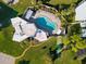 Aerial view of kidney-shaped pool, lounge chairs, and courts at 3880 Ironwood Ln # 208E, Bradenton, FL 34209