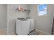 Functional laundry room with a washer, dryer, shelving and a bright window for natural light at 3931 Lively Coral Pl, Bradenton, FL 34208