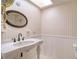 Bathroom with pedestal sink, skylight, and wainscoting at 4452 Garnet Dr # 205, New Port Richey, FL 34652