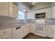 Functional kitchen with white cabinets, appliances, and a sink under a window for natural light at 4452 Garnet Dr # 205, New Port Richey, FL 34652