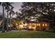 Two story house exterior at dusk with palm trees and a circular driveway at 4511 Bay Shore Rd, Sarasota, FL 34234