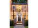 Two-story house entrance with a balcony, lanterns, and lush greenery at 4511 Bay Shore Rd, Sarasota, FL 34234