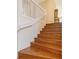 Elegant wooden staircase with white railing leading to the upper level at 4517 Streamside Ct # 1905, Sarasota, FL 34238