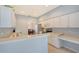 Clean kitchen with white cabinets, stainless steel appliances and a built-in desk area at 4517 Streamside Ct # 1905, Sarasota, FL 34238