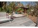 Relaxing patio area with wooden deck, storage shed, and lush tropical landscaping at 4925 Primrose Path, Sarasota, FL 34242