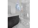 Bright bathroom with marble floors and shower featuring glass doors and dark vanity at 5910 Gulf Of Mexico Dr, Longboat Key, FL 34228