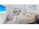 Cozy bedroom featuring a king bed with soft textures and view to a tropical yard at 5910 Gulf Of Mexico Dr, Longboat Key, FL 34228