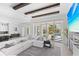Bright living room features beamed ceilings, a plush sectional sofa, and sliding glass doors to the outdoor pool area at 5910 Gulf Of Mexico Dr, Longboat Key, FL 34228