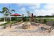 A community patio with a stone fire pit, comfortable lounge chairs, and beautiful lake views for outdoor enjoyment at 6771 Wild Lake Ter, Bradenton, FL 34212