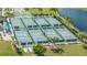 An aerial view of the community pickleball courts, featuring six courts with green and blue surfaces, surrounded by palm trees at 6771 Wild Lake Ter, Bradenton, FL 34212