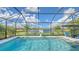 Enclosed pool area with lake view, basketball hoop, and patio furniture at 6771 Wild Lake Ter, Bradenton, FL 34212