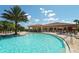Community pool with adjacent clubhouse and lounge chairs at 6771 Wild Lake Ter, Bradenton, FL 34212