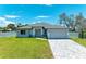 New construction home with gray exterior, gray paved driveway and landscaped lawn at 1010 Acadia Rd, Venice, FL 34293