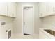 Bright laundry room with white cabinets and a stainless steel sink at 1010 Acadia Rd, Venice, FL 34293