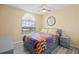 Cozy bedroom with a large window, neutral walls, gray wood-look floors and ceiling fan at 1228 50Th E St, Bradenton, FL 34208