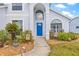 Charming home entrance, showcasing the blue front door and well-maintained landscaping at 1228 50Th E St, Bradenton, FL 34208