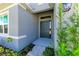 Modern dark-gray front door with sidelights, enhancing curb appeal at 12389 Cedar Pass Trl, Parrish, FL 34219