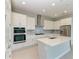 Modern kitchen with white cabinets, quartz countertops, and stainless steel appliances at 12389 Cedar Pass Trl, Parrish, FL 34219