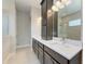 Double vanity bathroom with dark brown cabinets and white quartz countertops at 12389 Cedar Pass Trl, Parrish, FL 34219
