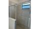 Modern shower with gray tile and frameless glass door at 15511 Sunny Day Dr, Lakewood Ranch, FL 34211