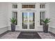 Modern building entrance with glass doors and potted plants at 15511 Sunny Day Dr, Lakewood Ranch, FL 34211