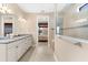 A bathroom with granite counters, double sinks, a walk in shower and a bedroom view at 17802 Eastbrook Ter, Lakewood Ranch, FL 34202