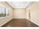A bright bedroom has a large window, tray ceiling and dark wood flooring at 17802 Eastbrook Ter, Lakewood Ranch, FL 34202