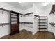 A walk-in closet with dark wood shelving, drawers, and wood-look tile flooring at 17802 Eastbrook Ter, Lakewood Ranch, FL 34202